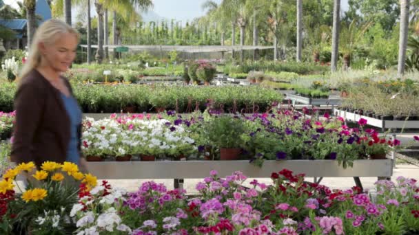 Mature Woman Smelling Flowers Garden Center — Stock Video