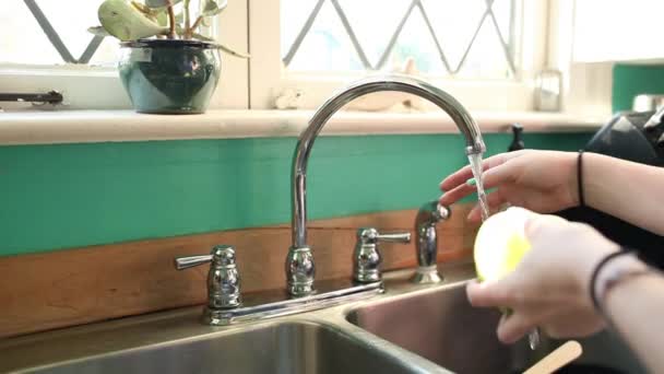 Έφηβη Κοπέλα Πλένει Μήλο Στο Νεροχύτη Κουζίνα — Αρχείο Βίντεο