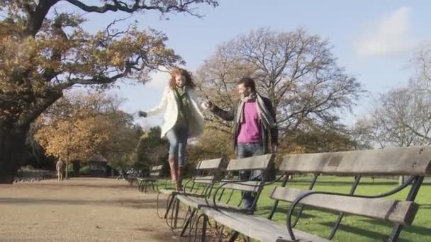 カップルの保有物手とベンチの上を歩く女性 — ストック動画