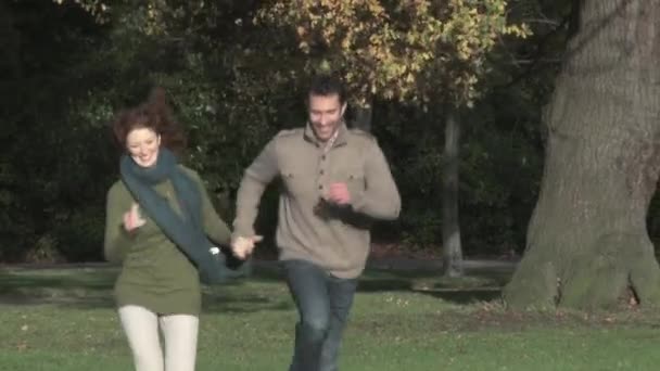 Paar Rennt Und Lächelt Herbstpark — Stockvideo