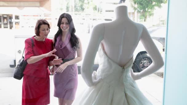 母亲和女儿在商店橱窗里看婚纱 — 图库视频影像