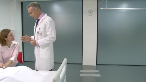 医生与男性病人和他的妻子交谈 — 图库视频影像