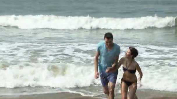 Pareja Sonriendo Huyendo Del Mar — Vídeos de Stock