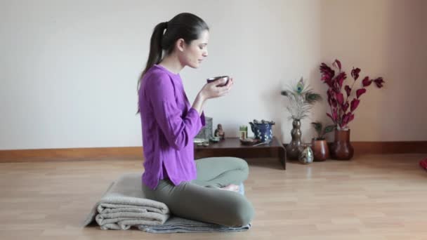 草茶を飲んで足を組んで座っている女性 — ストック動画