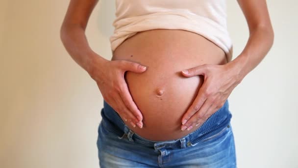 怀孕的妇女做心脏形状与手在腹部 — 图库视频影像