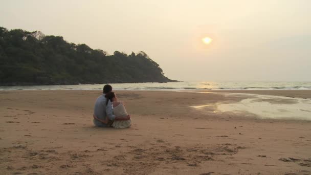 Paar Sitzt Bei Sonnenuntergang Strand Und Blickt Auf Die Aussicht — Stockvideo