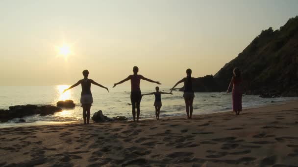 日落时在海滩上练习瑜伽的人 — 图库视频影像