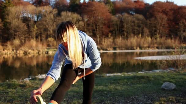 Genç Kadın Nehir Kıyısında Uzanan Spor Giyim — Stok video