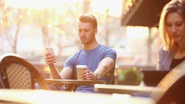 Joven Bebiendo Café Usando Smartphone Cafetería — Vídeos de Stock