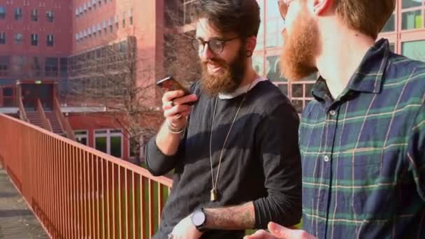 Δύο Νέοι Άνδρες Που Χρησιμοποιούν Smartphone Στο Δρόμο — Αρχείο Βίντεο