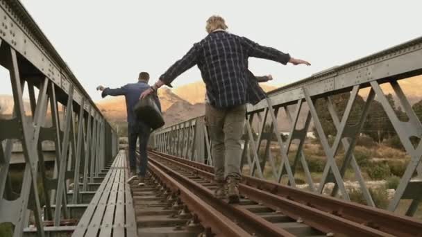 鉄道線路の上を歩く男性の背面図 — ストック動画