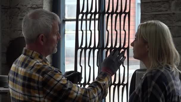 成熟的男人和女人看着金属栅格 — 图库视频影像