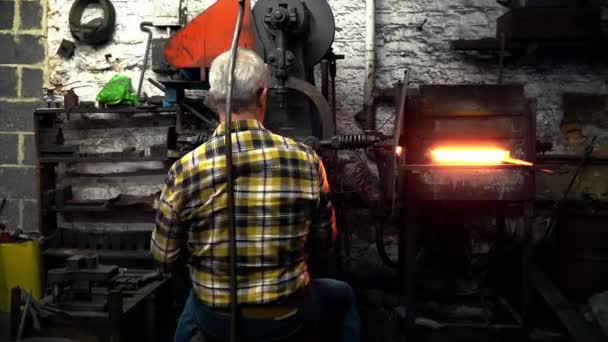 铁匠将金属插入熔炉的后视图 — 图库视频影像