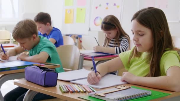 Mädchen Und Jungen Schreibtisch Der Grundschule — Stockvideo