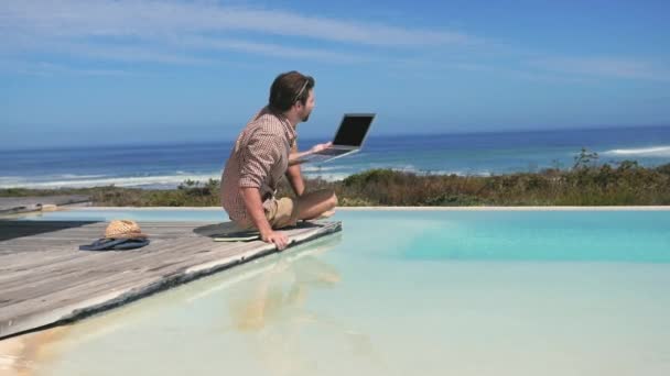 Young Man Using Laptop Pool — Stock Video