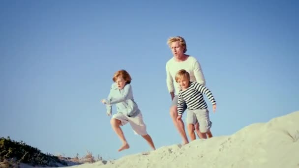 Vader Met Zonen Springen Strand Zand — Stockvideo