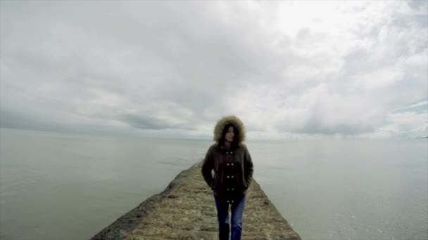 曇りの天候で桟橋の上を歩く女性 — ストック動画