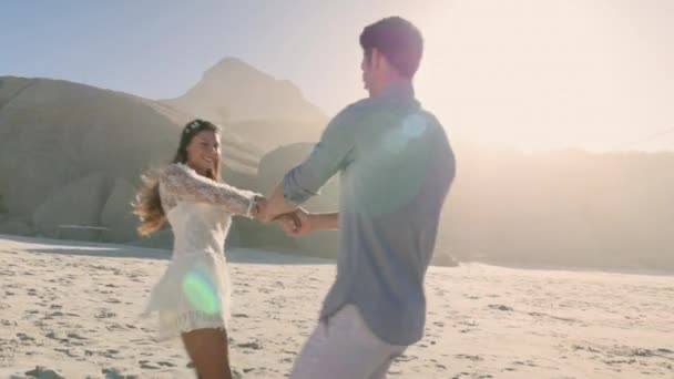 若いカップルは手を握って ビーチでスピニング — ストック動画