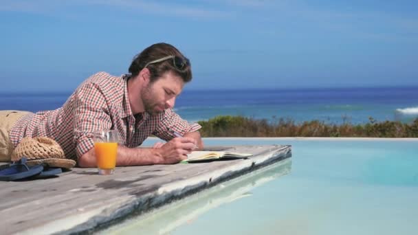 Joven Escribiendo Cuaderno Junto Piscina — Vídeos de Stock