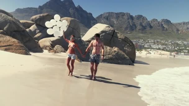 Paar Met Lucht Ballonnen Lopen Het Strand — Stockvideo