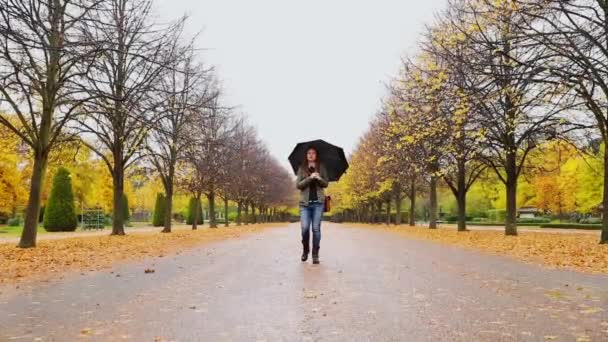 女人带着雨伞在公园里散步 — 图库视频影像