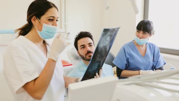 Οδοντίατρος Που Εξηγεί Την Εικόνα Ακτίνων Ασθενή — Αρχείο Βίντεο