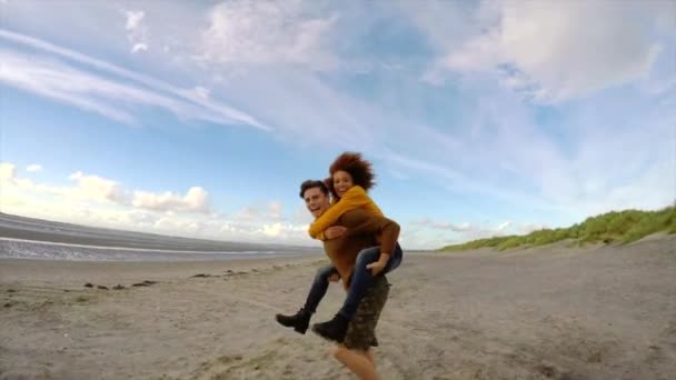 Man Loopt Strand Met Vrouw Achterop — Stockvideo