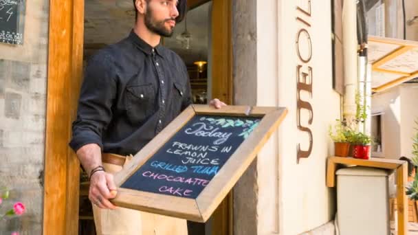 Man Placing Blackboard Menu — Stock Video