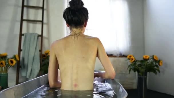 坐在钢制浴缸里的年轻女子的后视镜 — 图库视频影像
