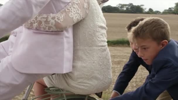 Crianças Empurrando Bicicleta Com Recém Casados Paisagem Rural — Vídeo de Stock