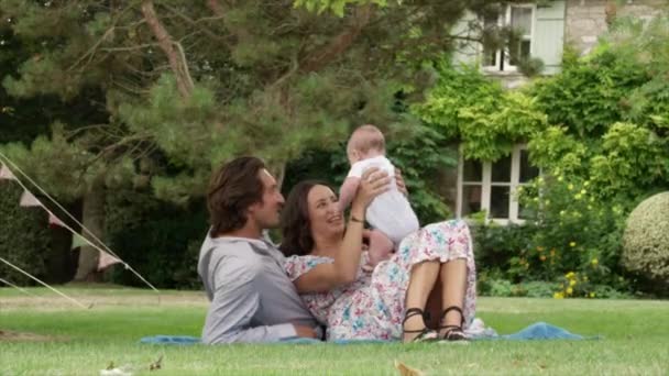 Pareja Acostada Jardín Jugando Con Niño — Vídeos de Stock