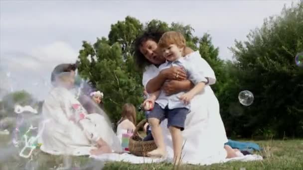 Vrouwen Kinderen Kijken Naar Zeepbellen Bij Picknick — Stockvideo