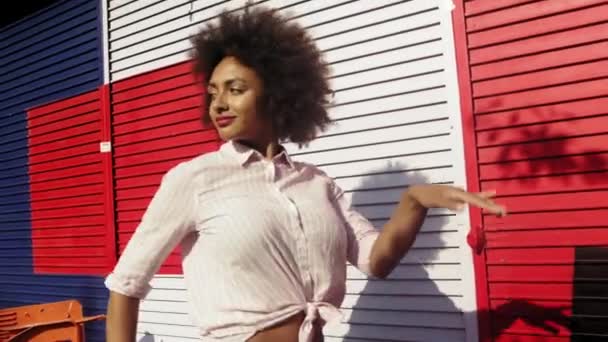 カラフルな壁に対して踊る若い女性ハックニー ロンドン イギリス イギリス — ストック動画