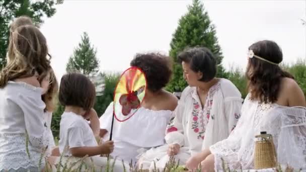 Ws女性と女の子 草の上に座って英国ウィルトシャー州ディントンを話す — ストック動画