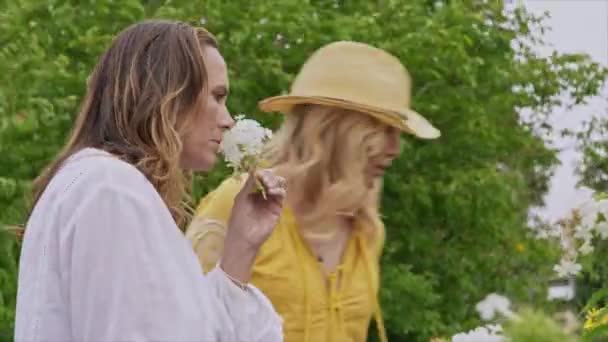 Donne Che Odorano Fiori Nel Giardino Estivo — Video Stock