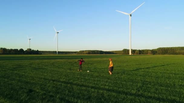 在风力涡轮机旁踢足球的儿童 — 图库视频影像