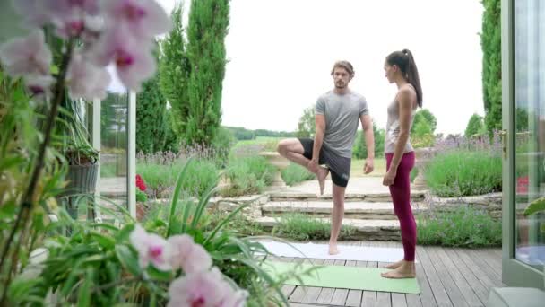 Uomo Che Pratica Albero Posa Con Istruttore Sul Patio — Video Stock