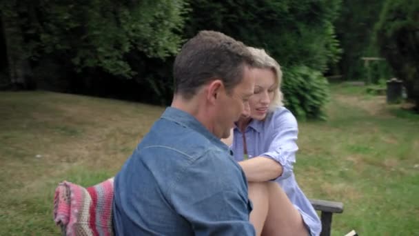 成熟的夫妇坐在长凳上看书 — 图库视频影像