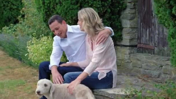 庭で成熟したカップルのふれあい犬 — ストック動画