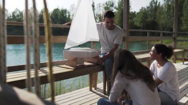 Mann Zeigt Freunden Segelboot Modell — Stockvideo