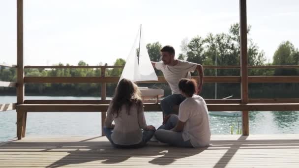 Man Showing Sailboat Model Friends — Stock Video