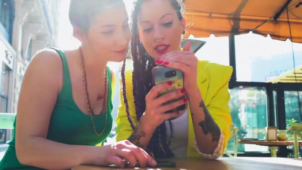 テーブルでスマートフォンを見ている若い女性 — ストック動画