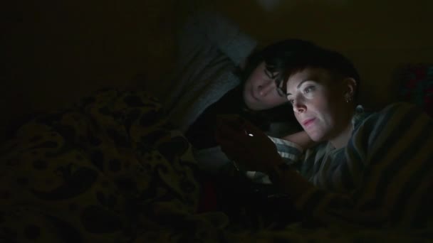 Две Молодые Женщины Используют Смартфон Ночью — стоковое видео