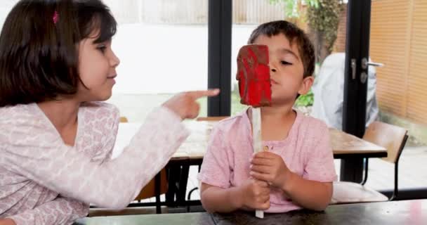 Menina Sorrindo Para Irmão Lambendo Creme Chocolate Espátula Cozinha — Vídeo de Stock