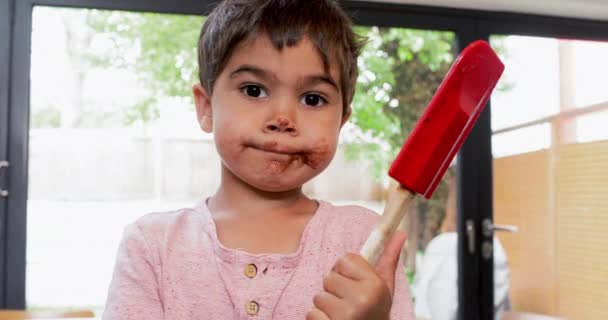 Junge Leckt Schokoladencreme Aus Spachtel — Stockvideo