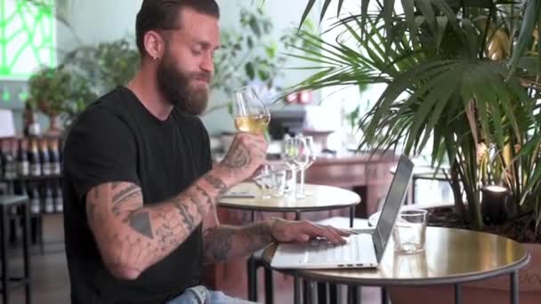 Человек Пьющий Белое Вино Пользующийся Ноутбуком Кафе — стоковое видео