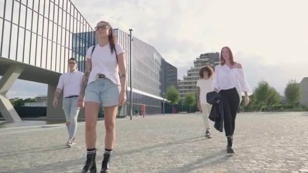 Fyra Vänner Går Torget Framför Modern Glasbyggnad — Stockvideo