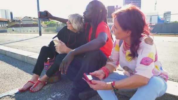Deux Femmes Homme Avec Des Dreadlocks Assis Sur Trottoir Prenant — Video