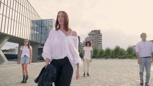 Quattro Amici Che Camminano Sulla Piazza Fronte Moderno Edificio Vetro — Video Stock