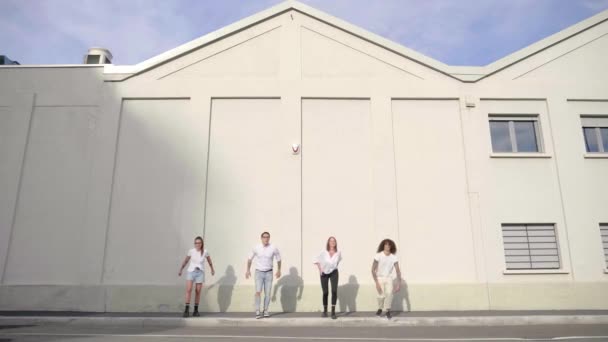 Quatro Amigos Pulando Frente Prédio — Vídeo de Stock